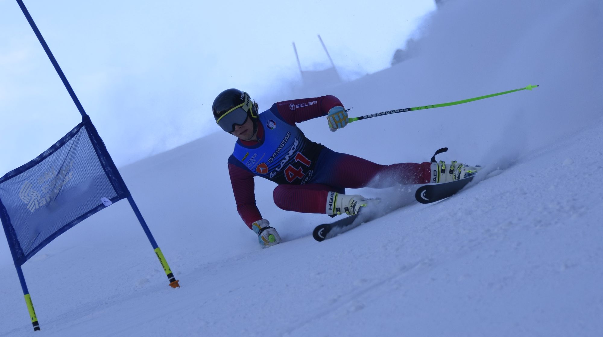 Giant slalom racer carving past a gate