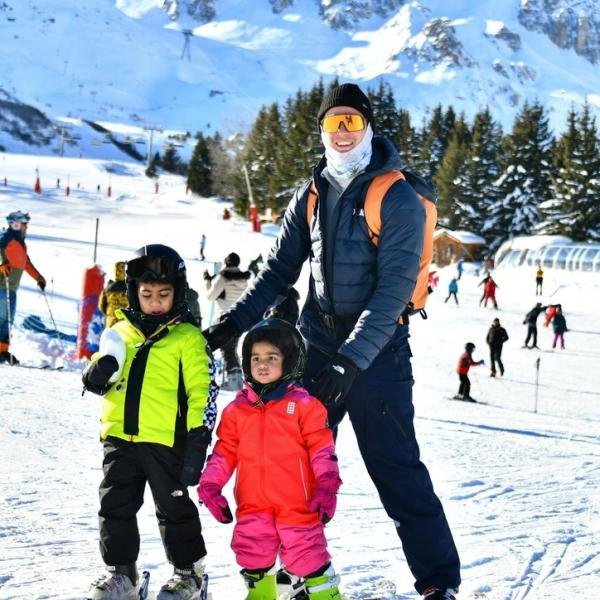 Instructor with two young children in their first ski lesson